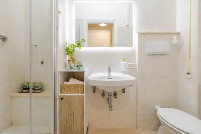 a white bathroom with a sink and a shower at Royal Vatican house JND in Rome