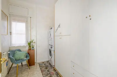 a laundry room with a washing machine and a chair at Royal Vatican house JND in Rome