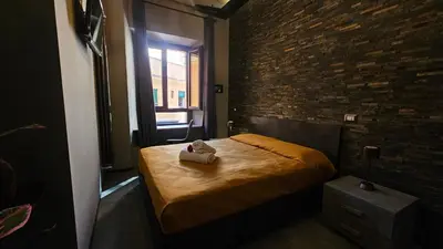 a bedroom with a bed and a brick wall at vatican street art in Rome