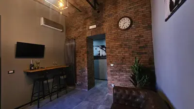 a room with a brick wall with a clock on the wall at vatican street art in Rome