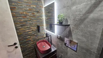 a bathroom with a red sink and a brick wall at vatican street art in Rome