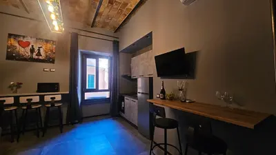 a room with a bar with stools and a television at vatican street art in Rome