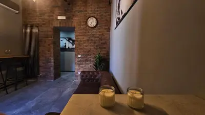 a living room with a couch and a clock on a wall at vatican street art in Rome