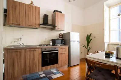 a small kitchen with a table and a refrigerator at Imperial House in Rome