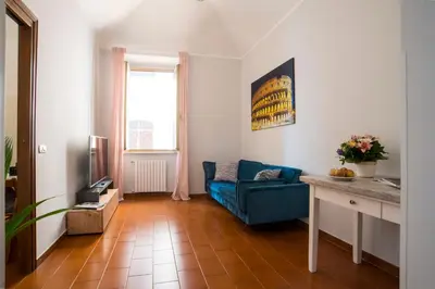 a living room with a blue couch and a television at Imperial House in Rome