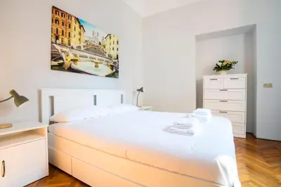 a bedroom with a large white bed and a dresser at Imperial House in Rome