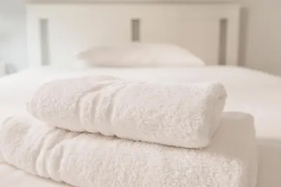 two stacks of white towels sitting on a bed at Imperial House in Rome
