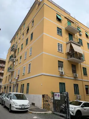 a yellow building with cars parked in front of it at San Giovanni Loft in Rome