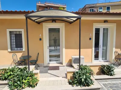 a patio with a table and chairs under an umbrella at Gemelli BnB Guest House in Rome