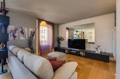 a living room with a couch and a television at Belli Vatican Attico - Luxury Design Rooftop Apartment close to Vatican City in Rome