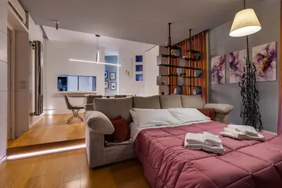a bedroom with a large bed with a red blanket at Belli Vatican Attico - Luxury Design Rooftop Apartment close to Vatican City in Rome