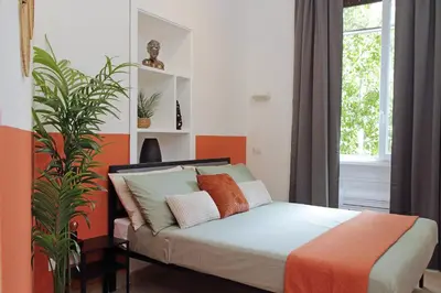 a bedroom with a bed with pillows and a plant at MAYA - Boutique Apartment in Rome