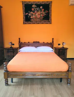 a bed in a room with an orange wall at L'Ottavo Re di Roma in Rome