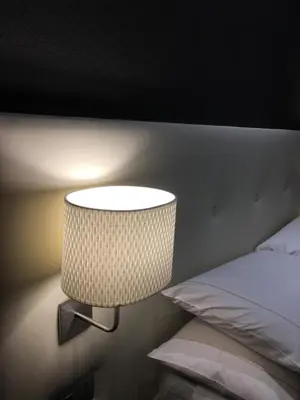 a lamp on a wall next to a bed at Piazza di Spagna Luxury Apartment in Rome