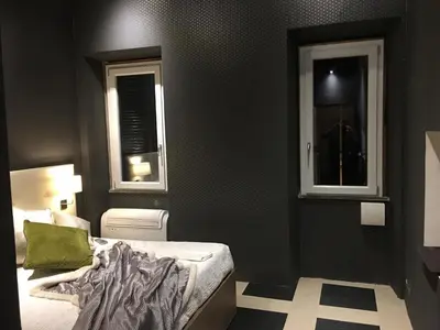 a bedroom with a bed and two windows at Piazza di Spagna Luxury Apartment in Rome