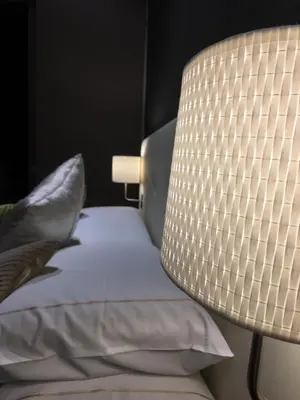 a lamp sitting next to a bed with pillows at Piazza di Spagna Luxury Apartment in Rome