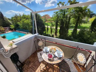 a table on a balcony with a view of a pool at Venus Inn Casa Vacanze AURELIA ANTICA in Rome