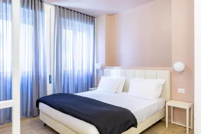 a bedroom with a large bed with blue curtains at Luciano Trastevere Guest House in Rome