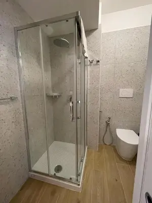 a shower with a glass door in a bathroom at Luciano Trastevere Guest House in Rome