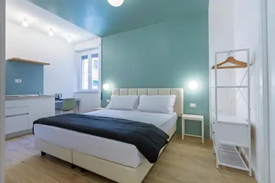 a bedroom with a white bed and a blue wall at Luciano Trastevere Guest House in Rome
