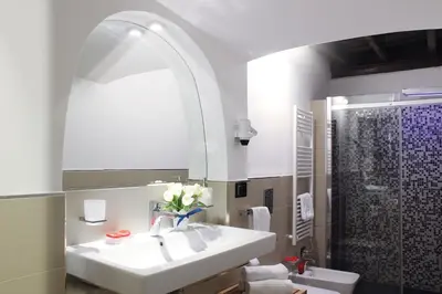 a white bathroom with a sink and a shower at Hub Navona in Rome