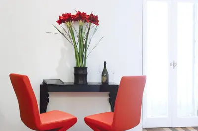 two red chairs and a table with a vase of flowers at Hub Navona in Rome