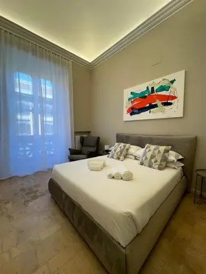 a bedroom with a large bed and a chair at èROMA - SANTA MARIA MAGGIORE BASILICA Apartment in Rome