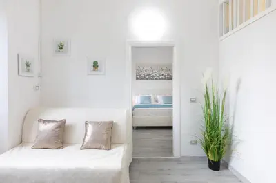 a white living room with a couch and a bed at Royal House Pigneto in Rome