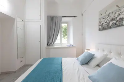 a white living room with a white couch and a tv at Royal House Pigneto in Rome