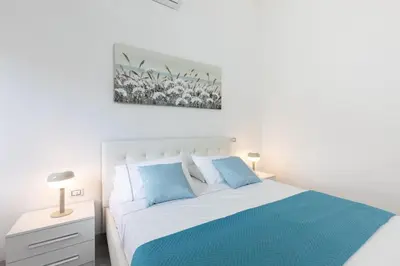 a white bedroom with a large bed and a window at Royal House Pigneto in Rome
