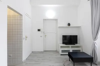 a white living room with a white couch and a tv at Royal House Pigneto in Rome