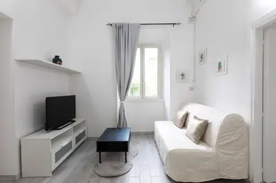 a white bedroom with a bed and a window at Royal House Pigneto in Rome