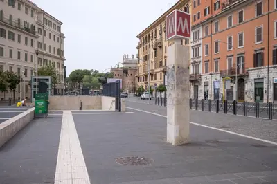 an empty city street with buildings and a clock tower at San Giovanni Charming Suites in Rome