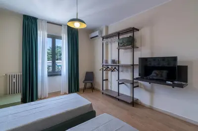 a living room with a bed and a flat screen tv at San Giovanni Charming Suites in Rome