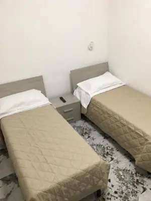 two beds in a room with a smashed floor at Bed&Breakfast MENNA in Rome