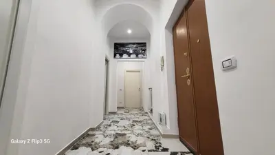 a hallway with a tile floor and a door at Bed&Breakfast MENNA in Rome