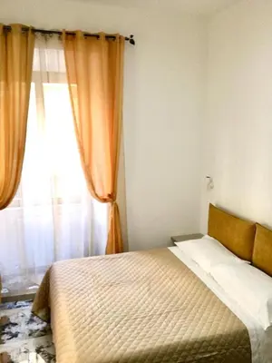 a bedroom with a bed and a window with curtains at Bed&Breakfast MENNA in Rome