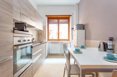 a kitchen with a table and a white counter top at St Peters Colorful 3BDR Apartment in Rome