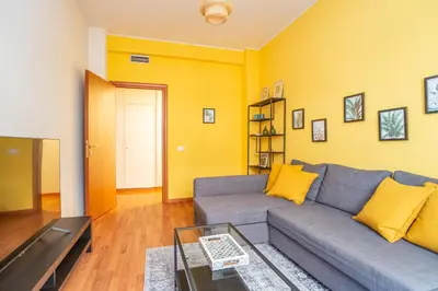 a living room with a gray couch and yellow walls at St Peters Colorful 3BDR Apartment in Rome