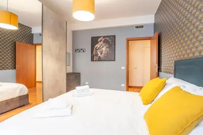 a bedroom with a large white bed and yellow pillows at St Peters Colorful 3BDR Apartment in Rome