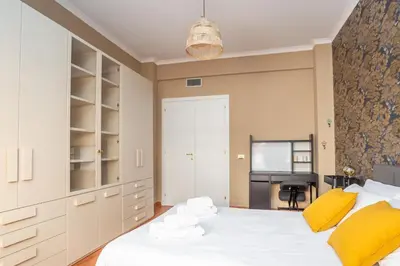 a bedroom with a large white bed with yellow pillows at St Peters Colorful 3BDR Apartment in Rome