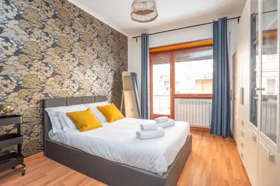 a bedroom with a bed with yellow pillows at St Peters Colorful 3BDR Apartment in Rome