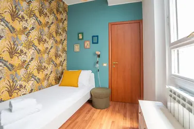 a room with a couch and a blue wall at St Peters Colorful 3BDR Apartment in Rome