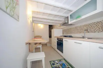 a white kitchen with a table and a sink at PANTHEON APARTMENT in the Heart of Rome in Rome