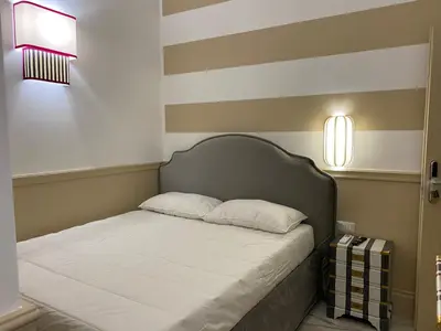 a bed in a room with a striped wall at Cozy Luxury Room Pantheon in Rome