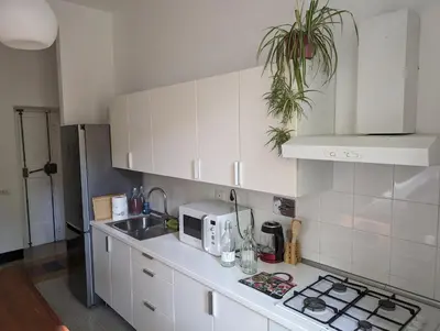 a kitchen with white cabinets and a microwave at Appartamento della Vittoria in Rome