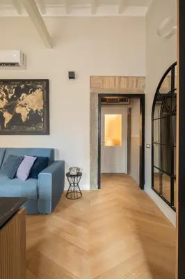a living room with a blue couch and wooden floors at THE BREAK - Campo Marzio Maison Deluxe in Rome