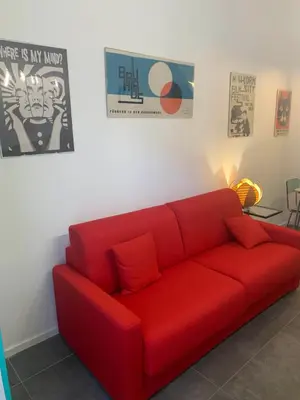 a red couch sitting in a living room at nel cuore di trastevere in Rome