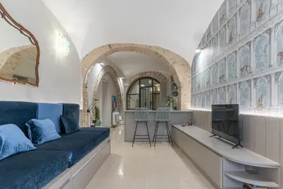 a living room with a blue couch and a tv at DomusLatina Monti - Luxury stay in the heart of Rome in Rome