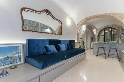 a living room with a blue couch and a kitchen at DomusLatina Monti - Luxury stay in the heart of Rome in Rome